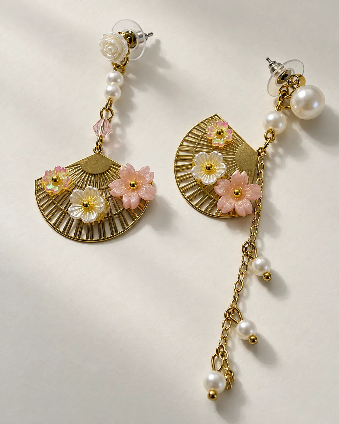 Angled view of the gold-tone fan earring and pearl-look chain drop