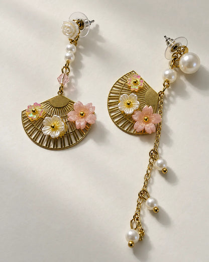 Angled view of the gold-tone fan earring and pearl-look chain drop