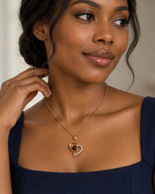 Model in a navy top wearing the rose gold projection heart necklace