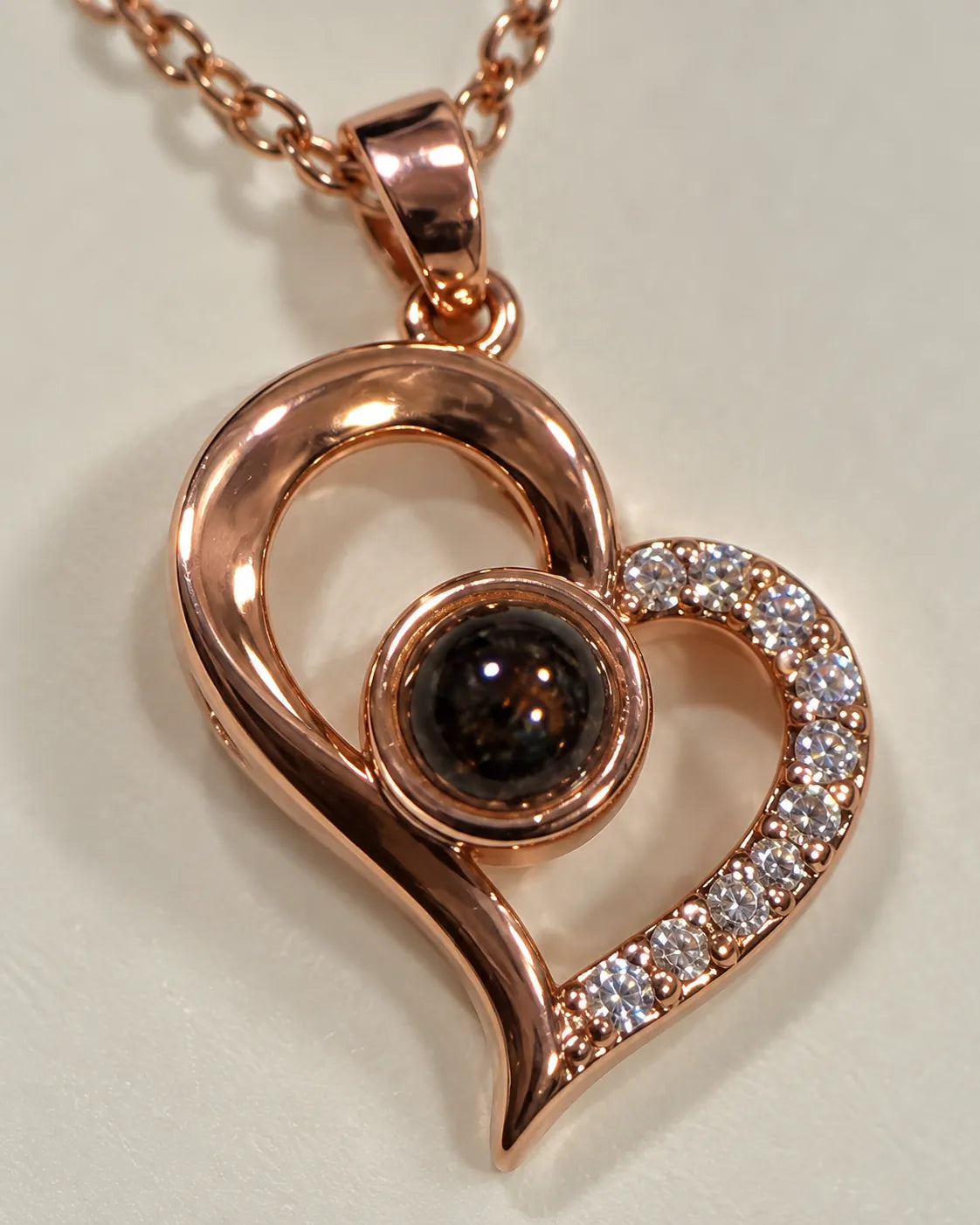 Close-up of the crystal-edged rose gold heart and round projection stone