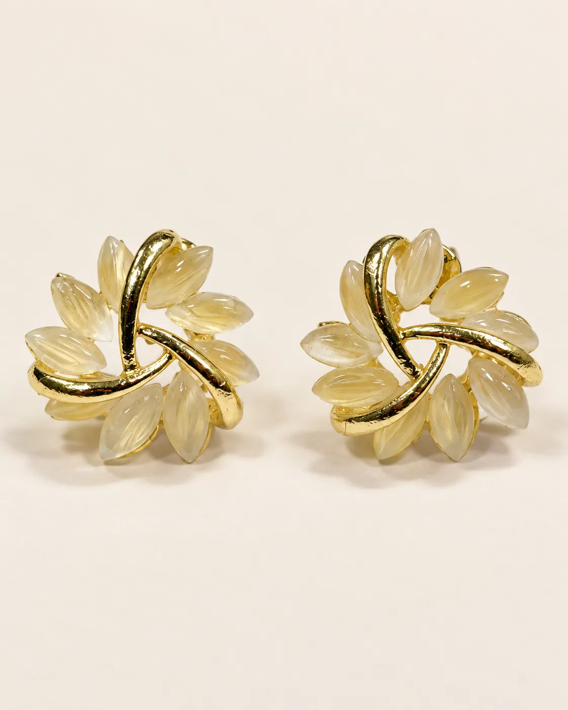 Pair of gold pinwheel flower stud earrings with pale opal petals, front view