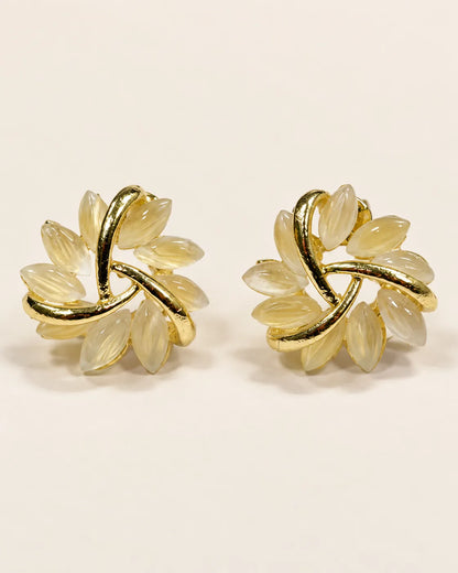 Pair of gold pinwheel flower stud earrings with pale opal petals, front view
