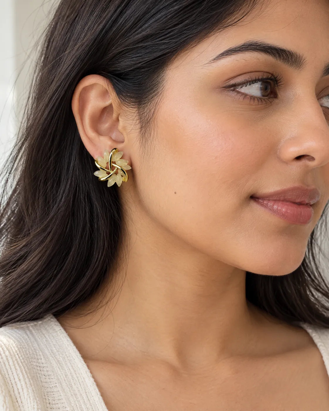 Close-up of a model wearing the gold opal flower petal stud