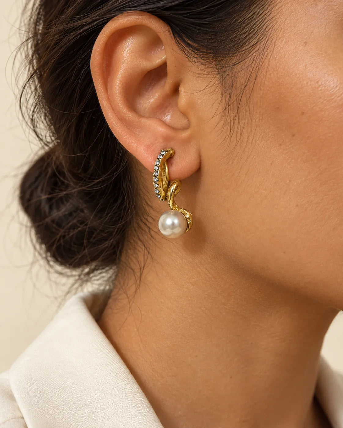 Close-up of the gold twisted pearl-look stud worn on the ear