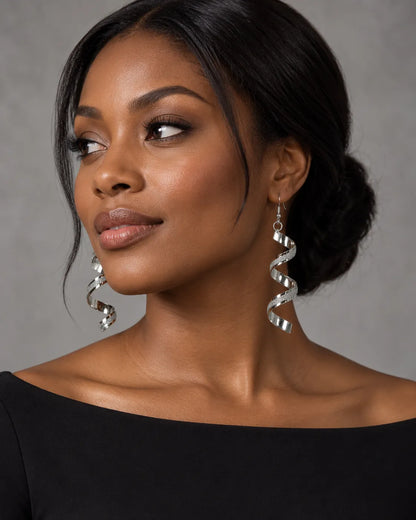 Model in a black off-the-shoulder top wearing the silver spiral drop earrings