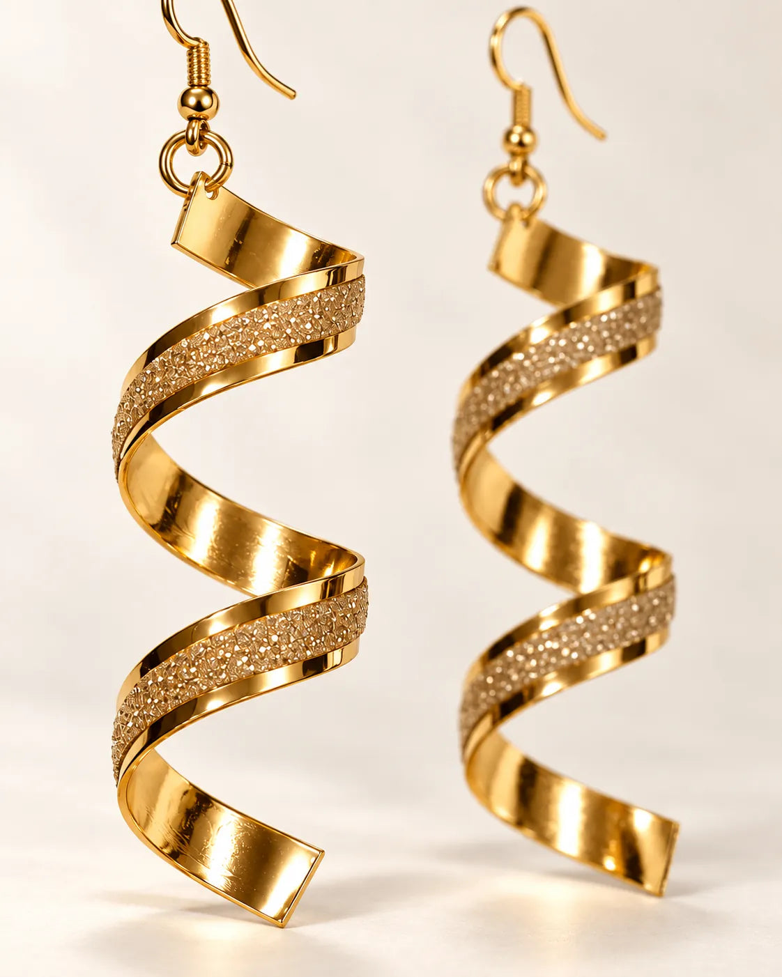 Close-up of the gold spiral earrings showing the frosted centre stripe
