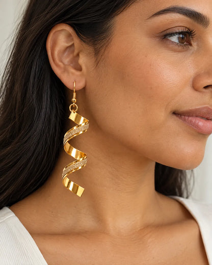Close-up of a model wearing a gold spiral earring with a white top