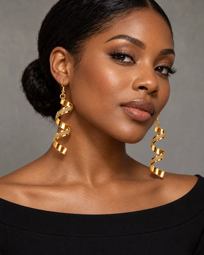 Model in a black top wearing the gold spiral statement earrings