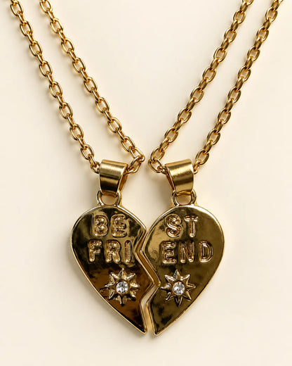 Gold-tone split heart best friend necklaces joined together on cream