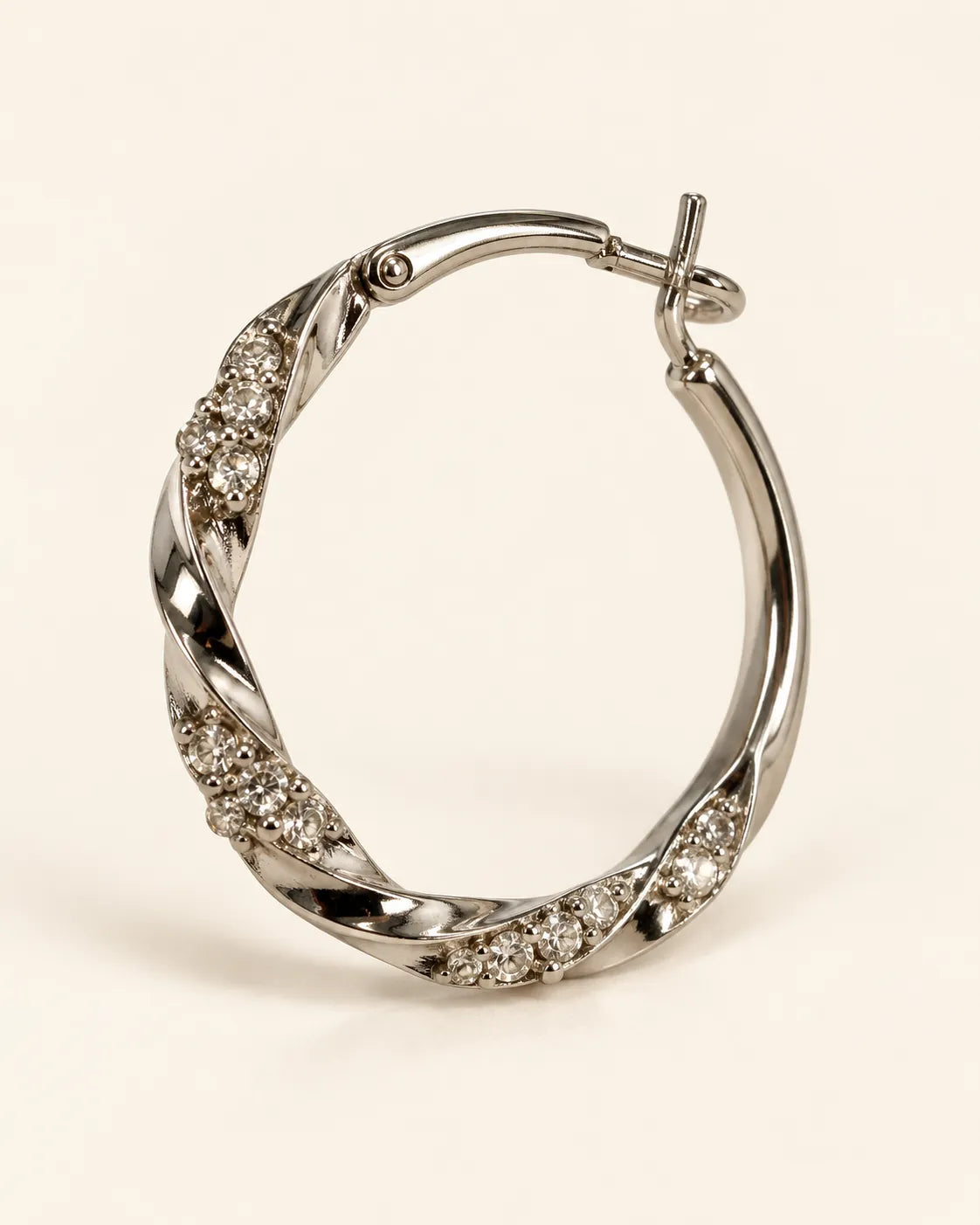 Close-up of one silver twisted hoop showing the rhinestone-set sections