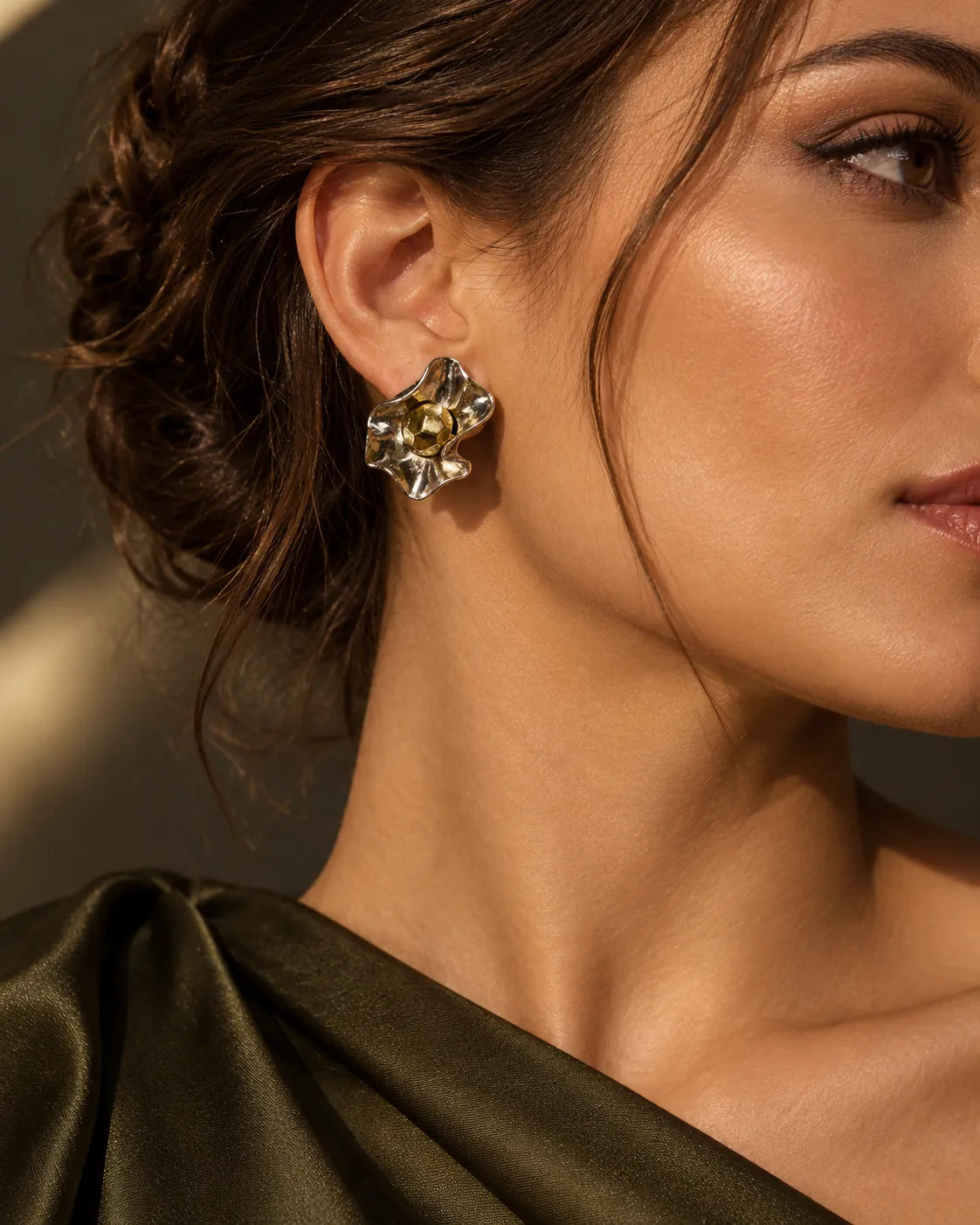 Model in an olive satin top wearing the mixed-metal flower stud earrings