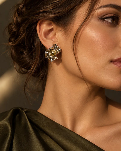 Model in an olive satin top wearing the mixed-metal flower stud earrings