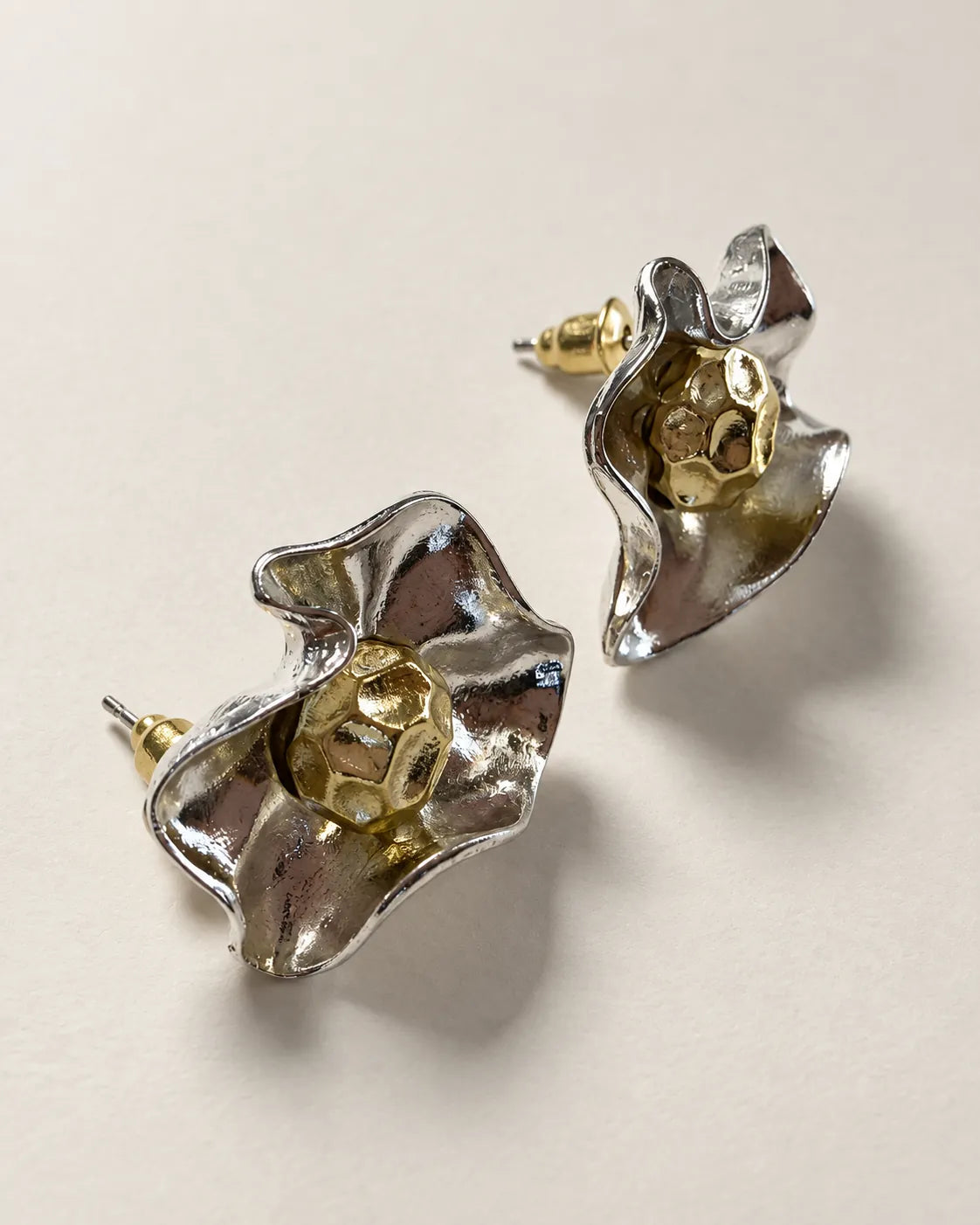 Angled view of the ruffled silver-tone flower studs showing the posts