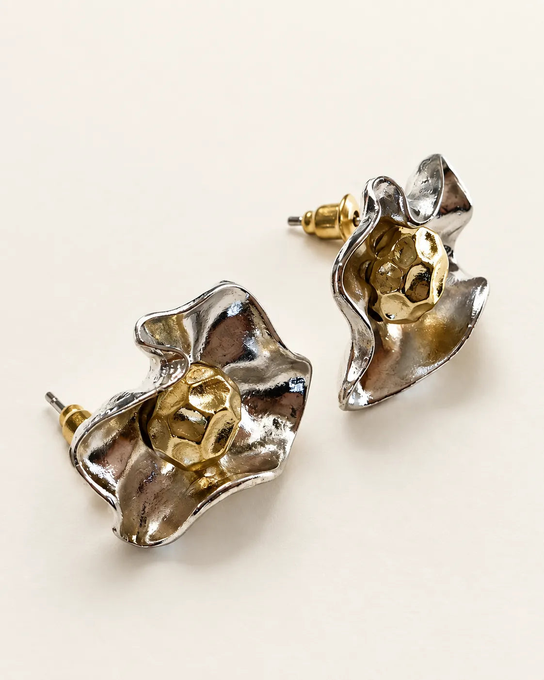 Pair of silver and gold-tone flower stud earrings on a white background