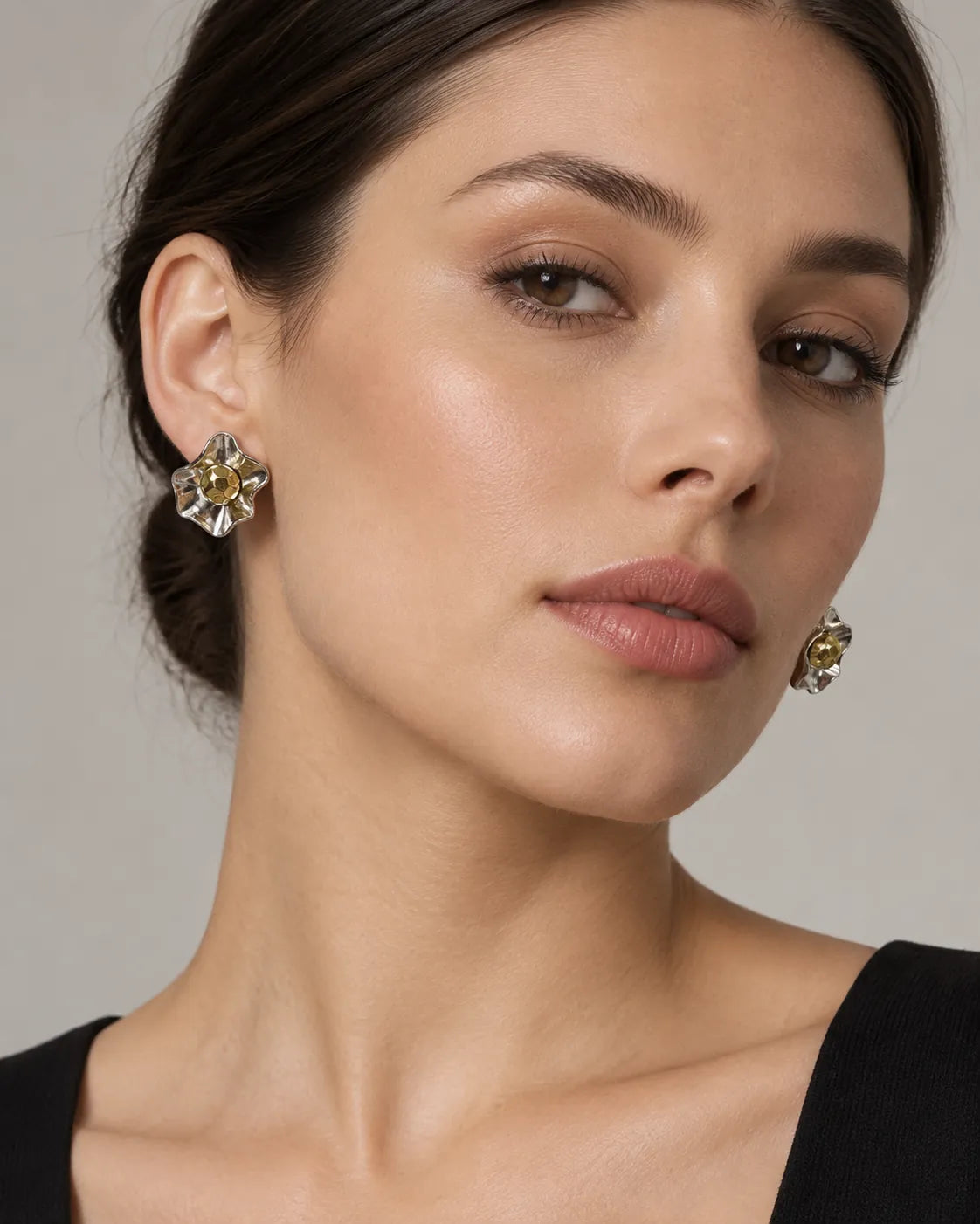 Model in a black top wearing the two-tone sculptural flower studs