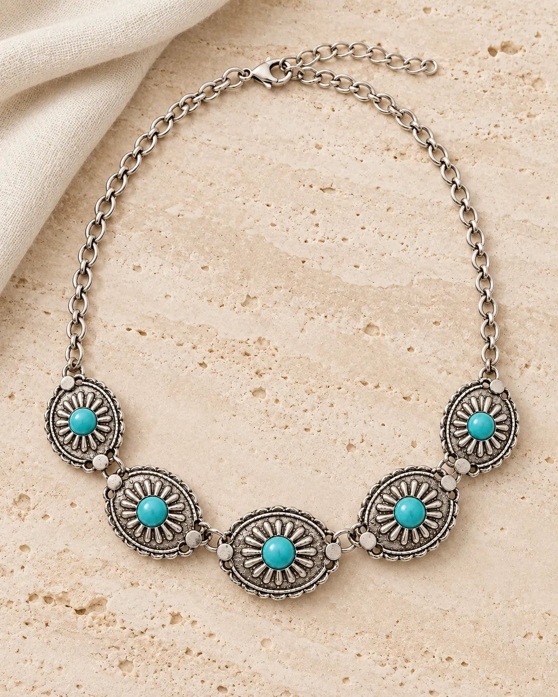 Antique silver-tone turquoise medallion choker on a stone surface