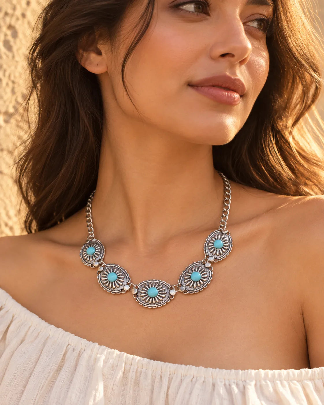 Model in an off-the-shoulder white top wearing the sunburst choker