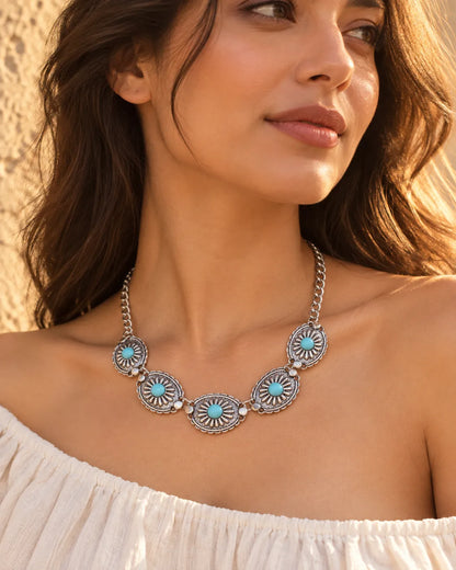 Model in an off-the-shoulder white top wearing the sunburst choker