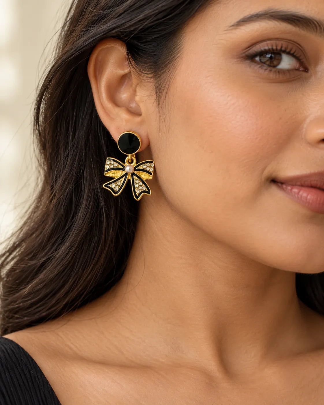 Close-up of the black rhinestone bow earring worn on the ear