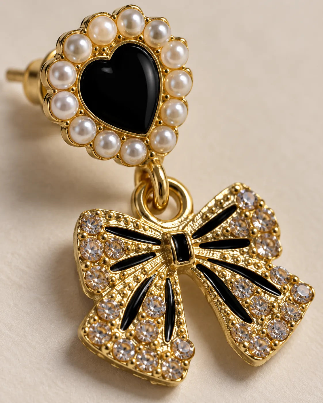 Close-up of the pearl-look framed black heart and rhinestone bow with black stripes