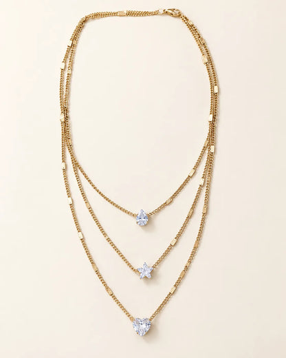 Gold-tone Celestial Sparkle three-layer crystal necklace on cream