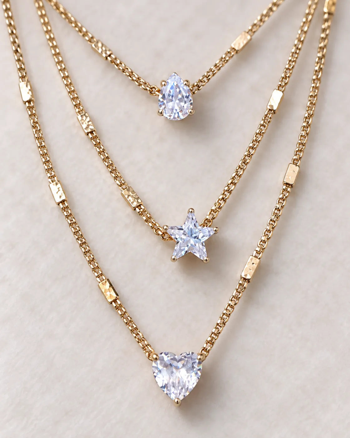 Close-up of the gold pear, star and heart crystal charms on each strand
