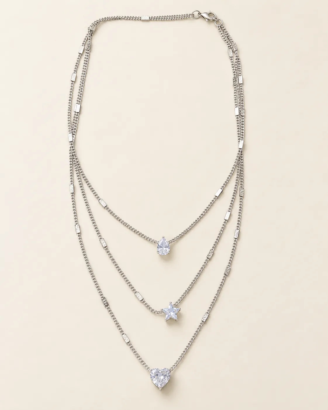 Silver-tone Celestial Sparkle three-layer crystal necklace on cream