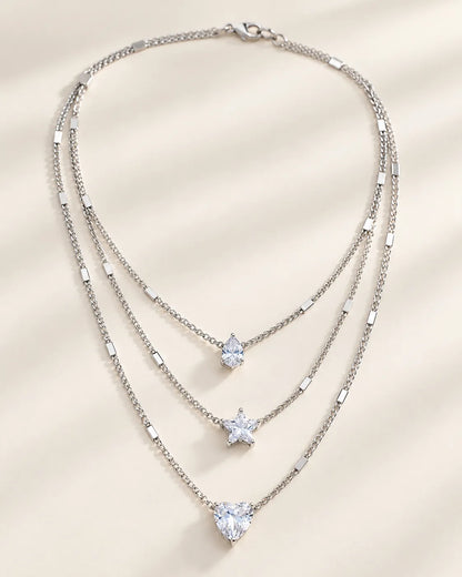 Silver three-strand crystal necklace laid flat, showing the graduated layers