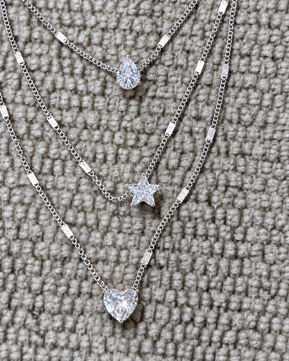 Close-up of the silver pear, star and heart crystals on grey knit fabric