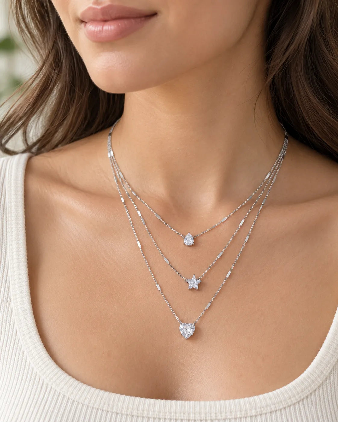 Model in a cream scoop-neck top wearing the silver layered crystal necklace