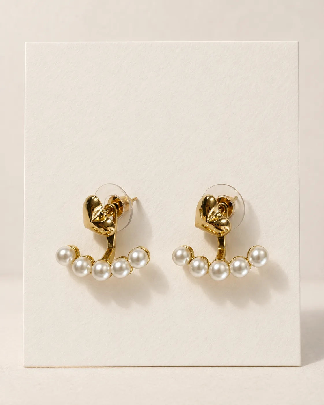 Gold heart and pearl-look studs on a display card