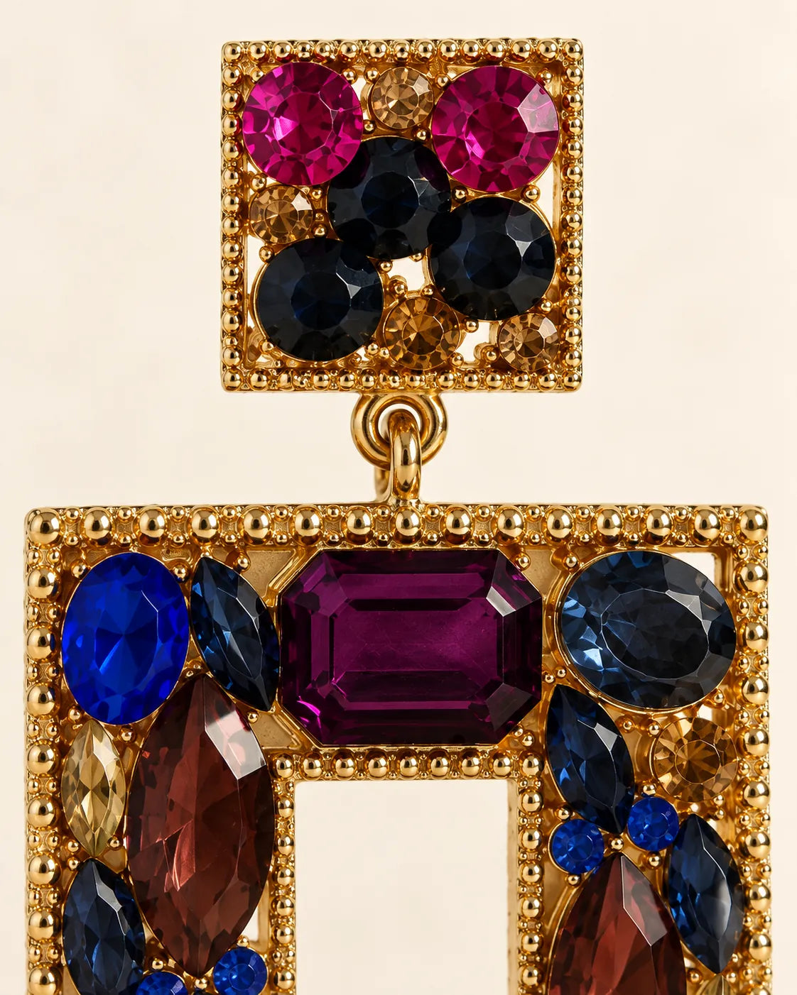 Close-up of the fuchsia and navy stud and faceted plum, cobalt and amber crystals