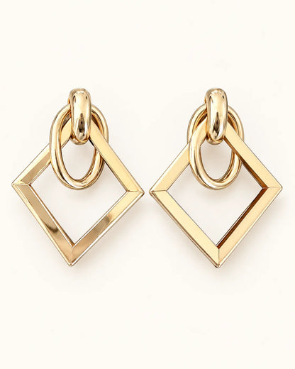 Élan gold geometric square drop earrings on a cream background