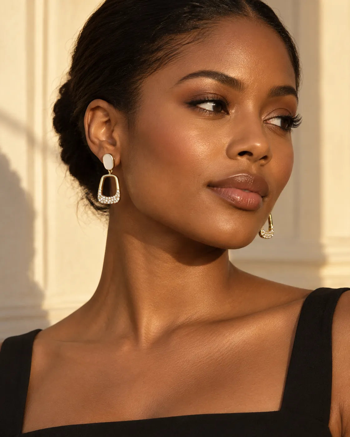 Model in a black top wearing the ivory-white oval stud drop earrings