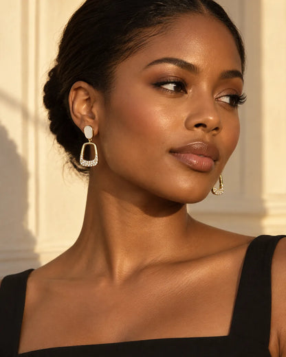 Model in a black top wearing the ivory-white oval stud drop earrings