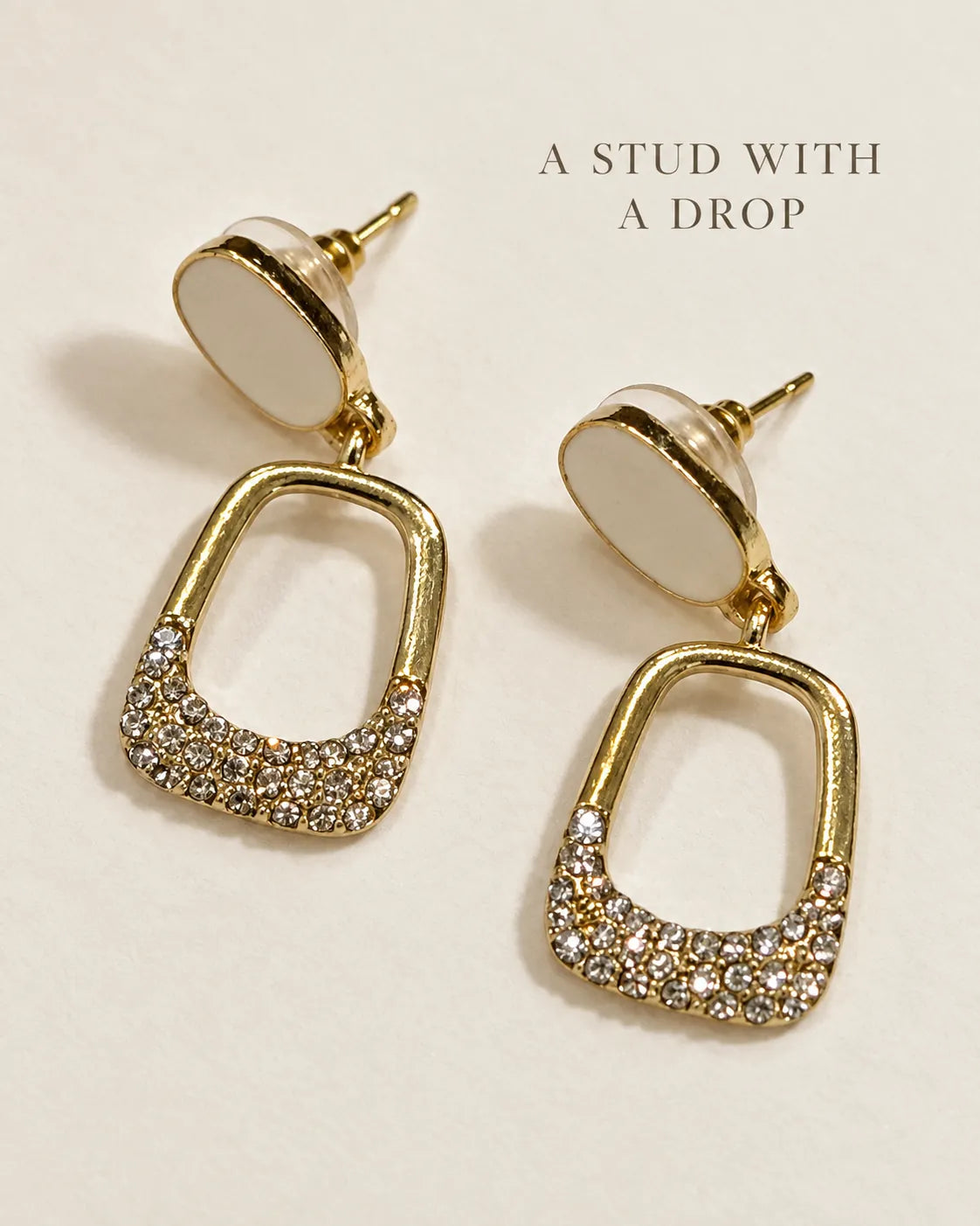 White stud drop earrings on a cream card with A Stud With A Drop text