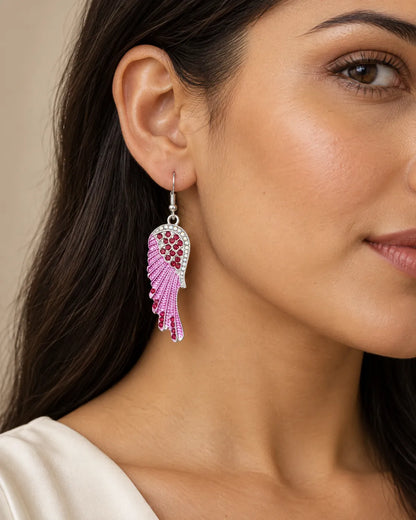 Close-up of a model's ear wearing the pink angel wing earring