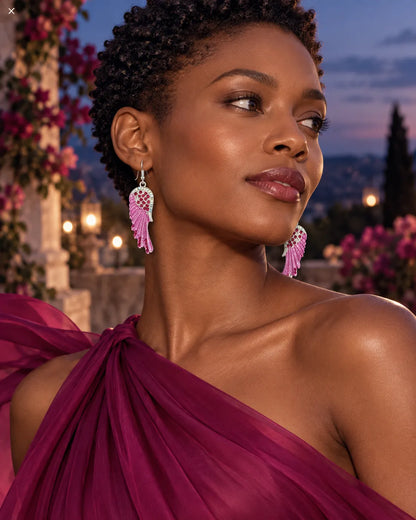 Model in a magenta draped dress wearing the pink wing earrings at dusk