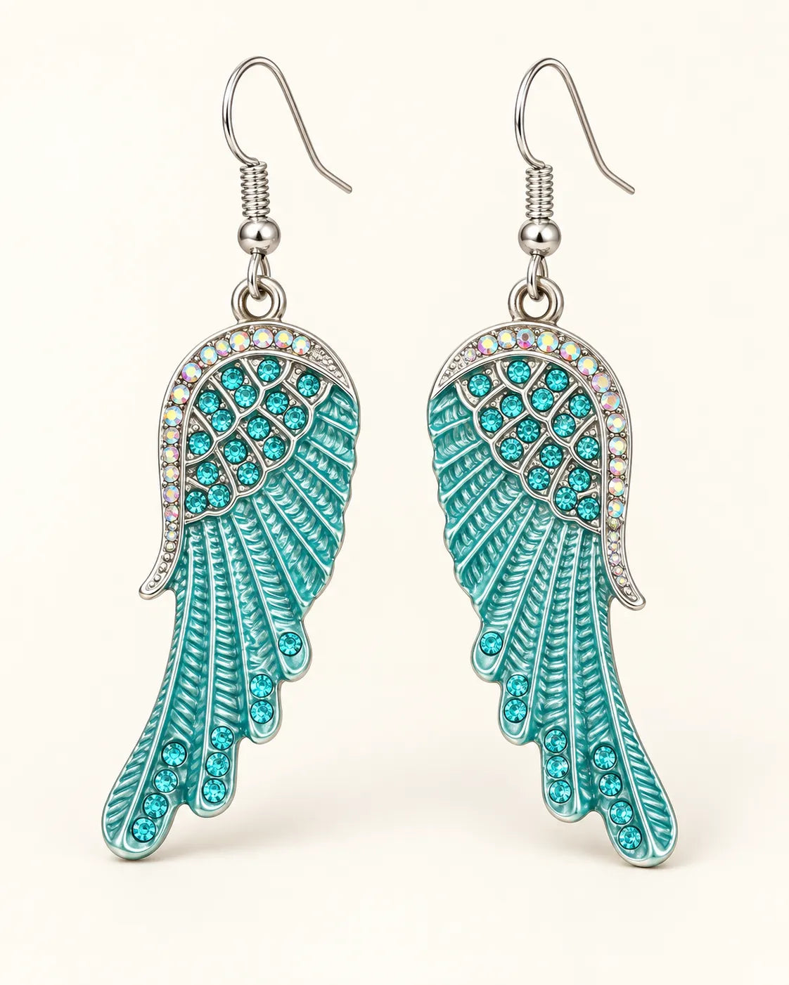 Turquoise-blue angel wing crystal earrings with fish-hook wires on a cream background