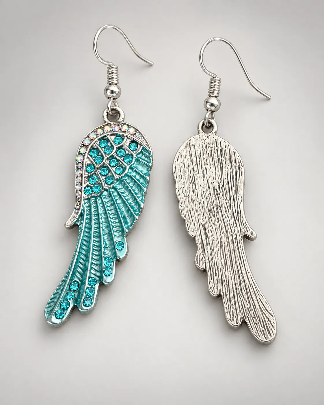 Front and textured silver-tone reverse of the blue angel wing earrings on grey