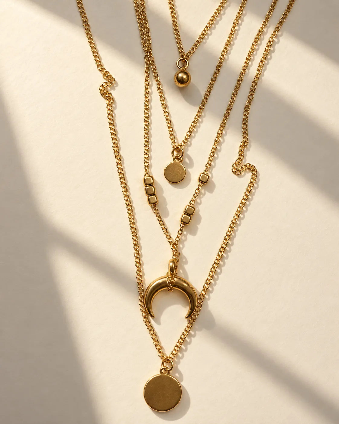 Gold layered moon necklace in sunlight showing the graduated strands