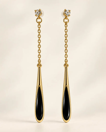Black teardrop long chain drop earrings with clear crystal studs on a cream background