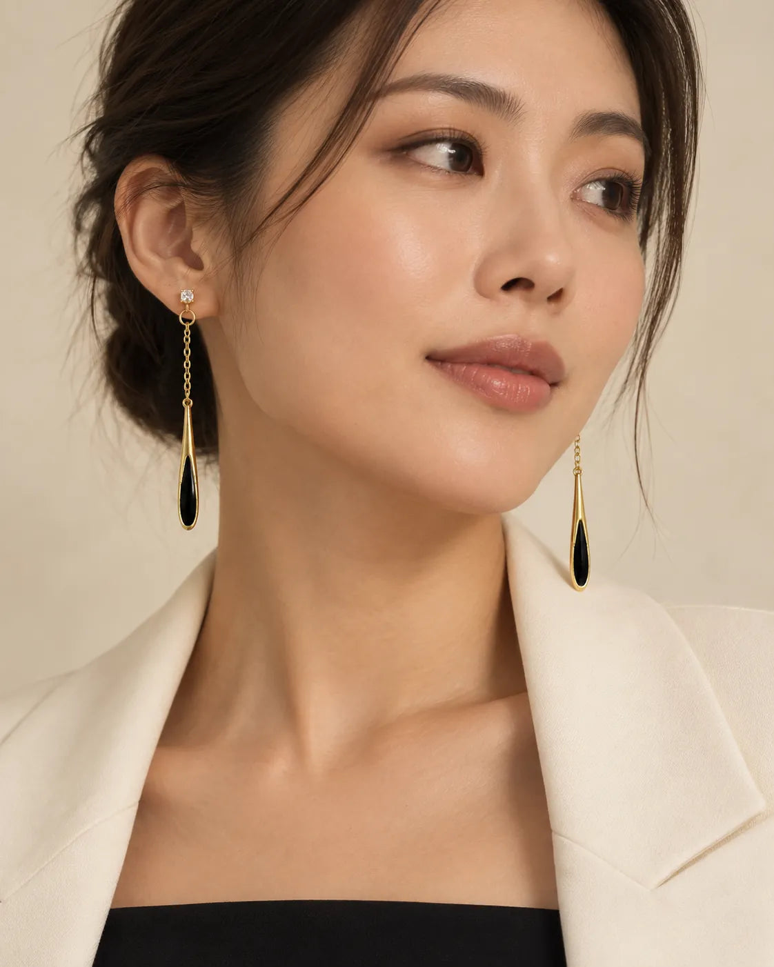 Model in a white blazer wearing the long black enamel drop earrings