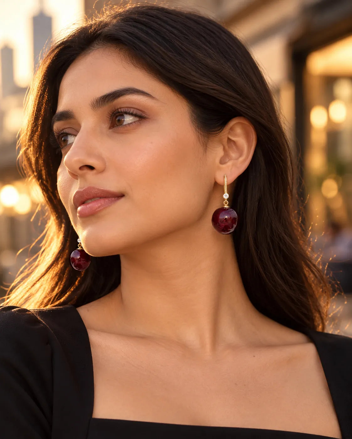 Model in a black top on a city street wearing the red cherry earrings