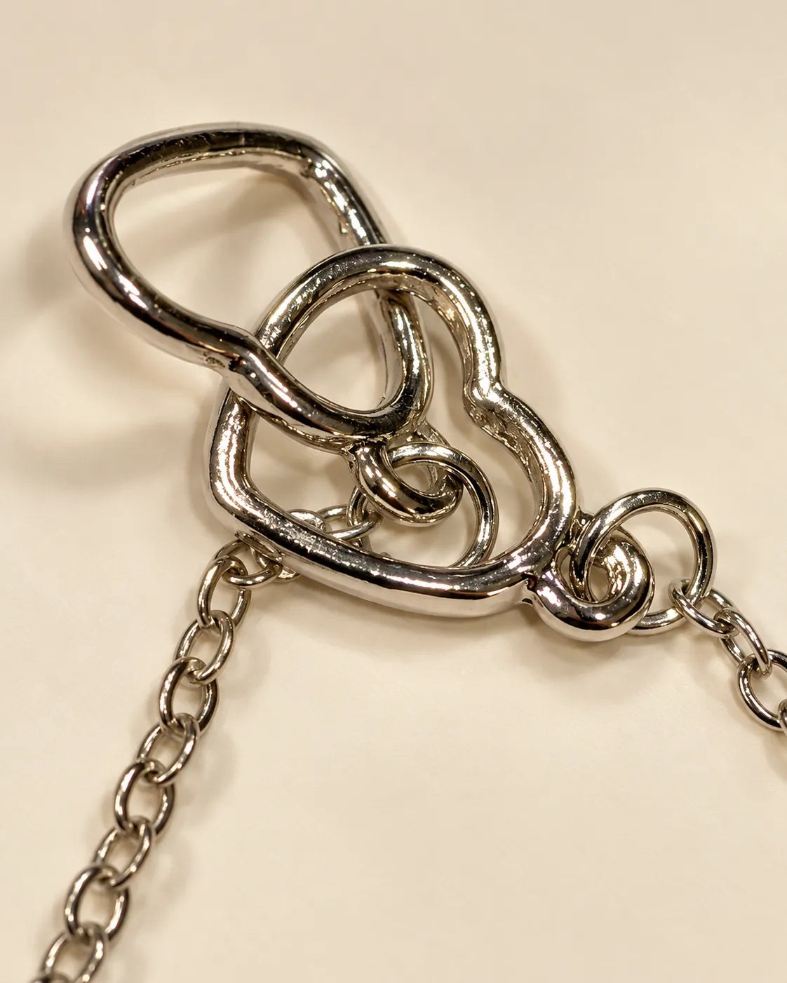 Close-up of the two polished silver hearts linked together