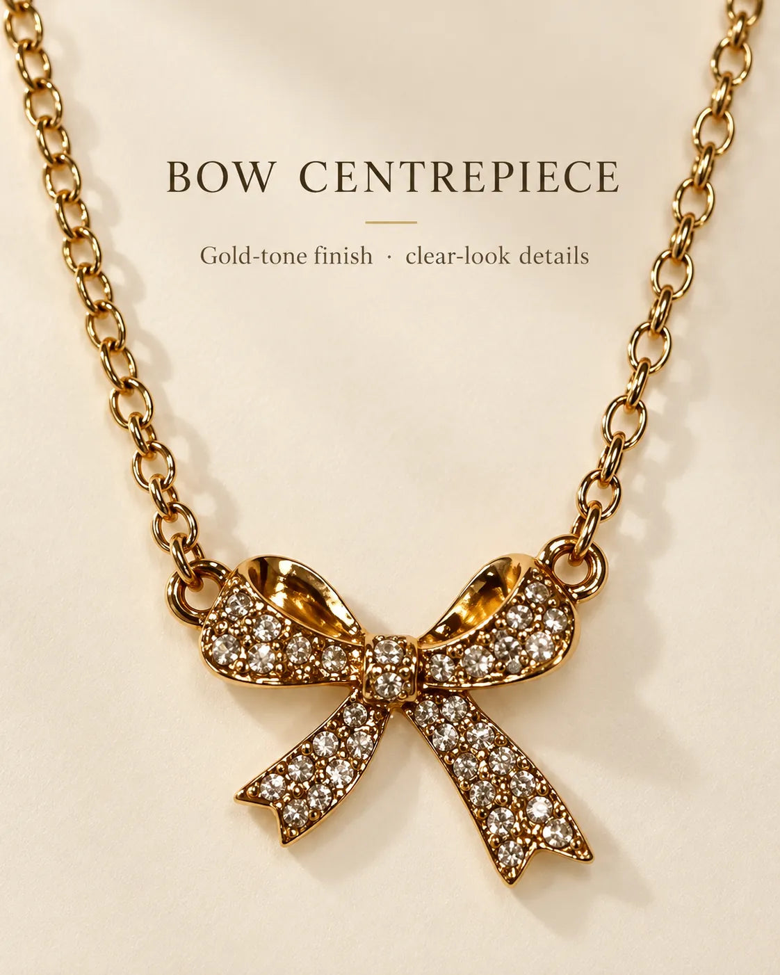 Gold bow necklace with Bow Centrepiece text on a cream background