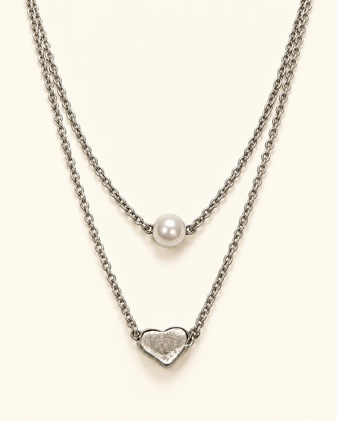 Silver two-layer necklace with pearl-look bead and heart on cream