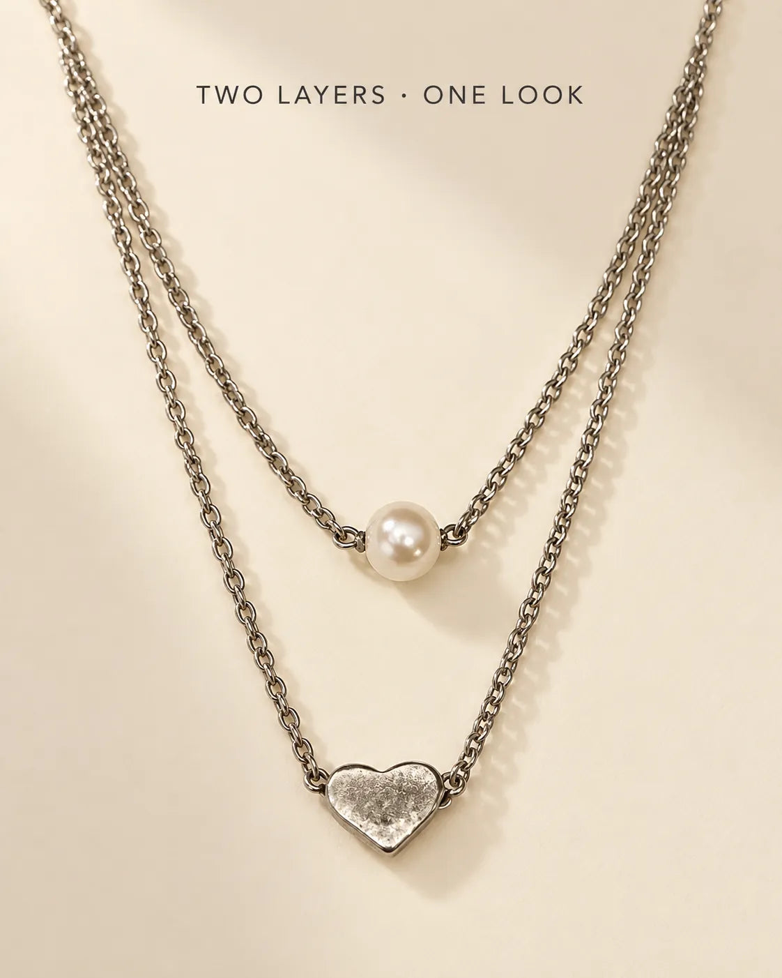 Silver layered pearl and heart necklace with Two Layers, One Look text