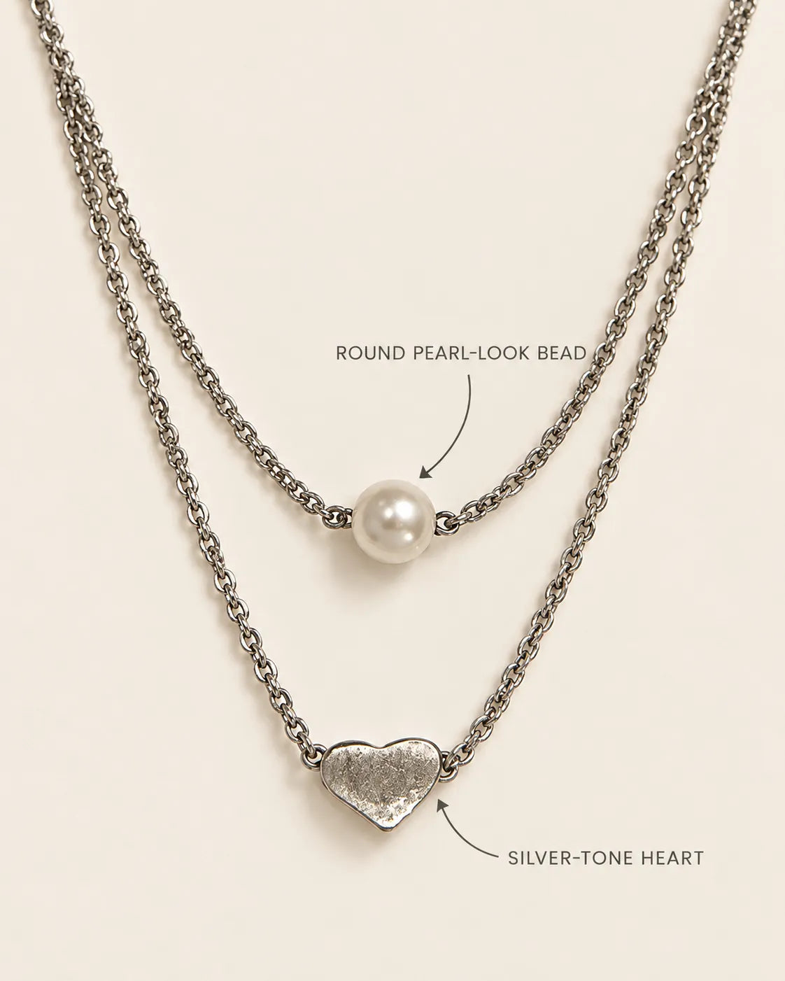 Annotated detail graphic of the pearl-look bead and silver-tone heart