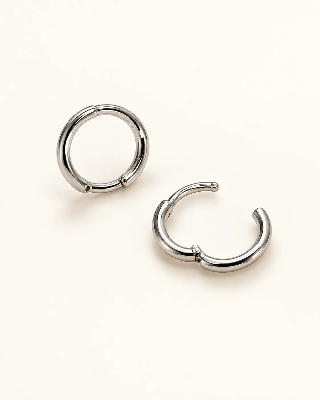Silver huggie hoops with one closed and one open to show the hinge